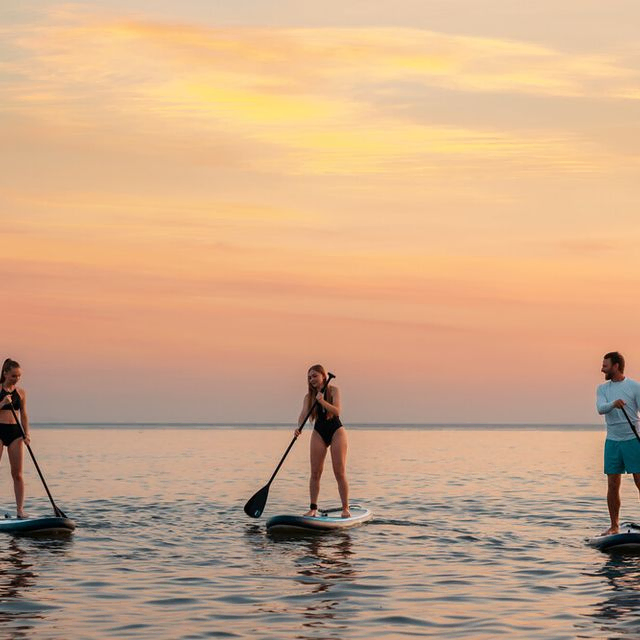 Grupo de amigos practicando paddle surf