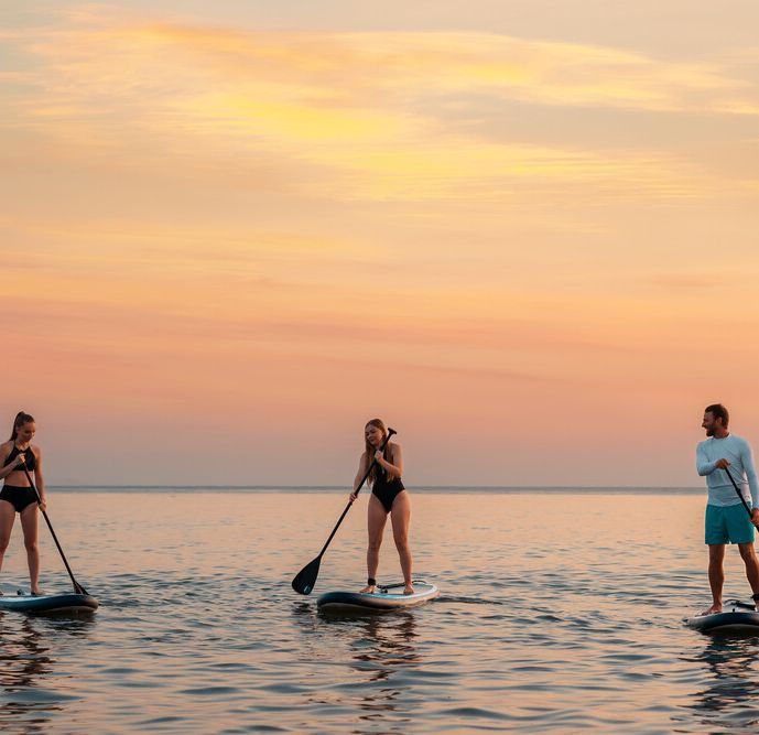 Grupo de amigos practicando paddle surf